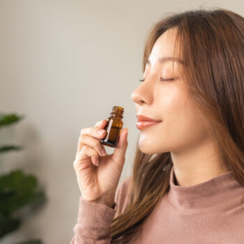 A woman inhaling essential oils to help with allergies