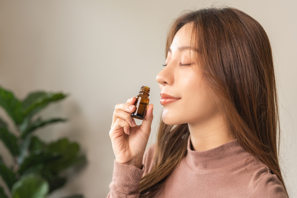 A woman inhaling essential oils to help with allergies