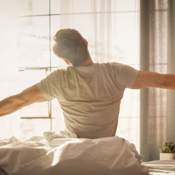 A man waking up in the morning after a good night's sleep